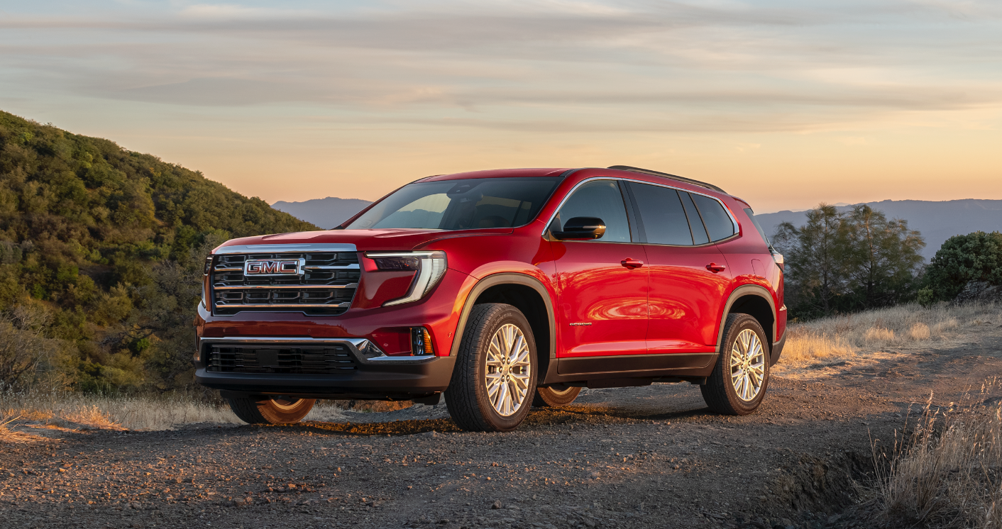 2026 GMC Acadia Elevation in red on a scenic mountain terrain