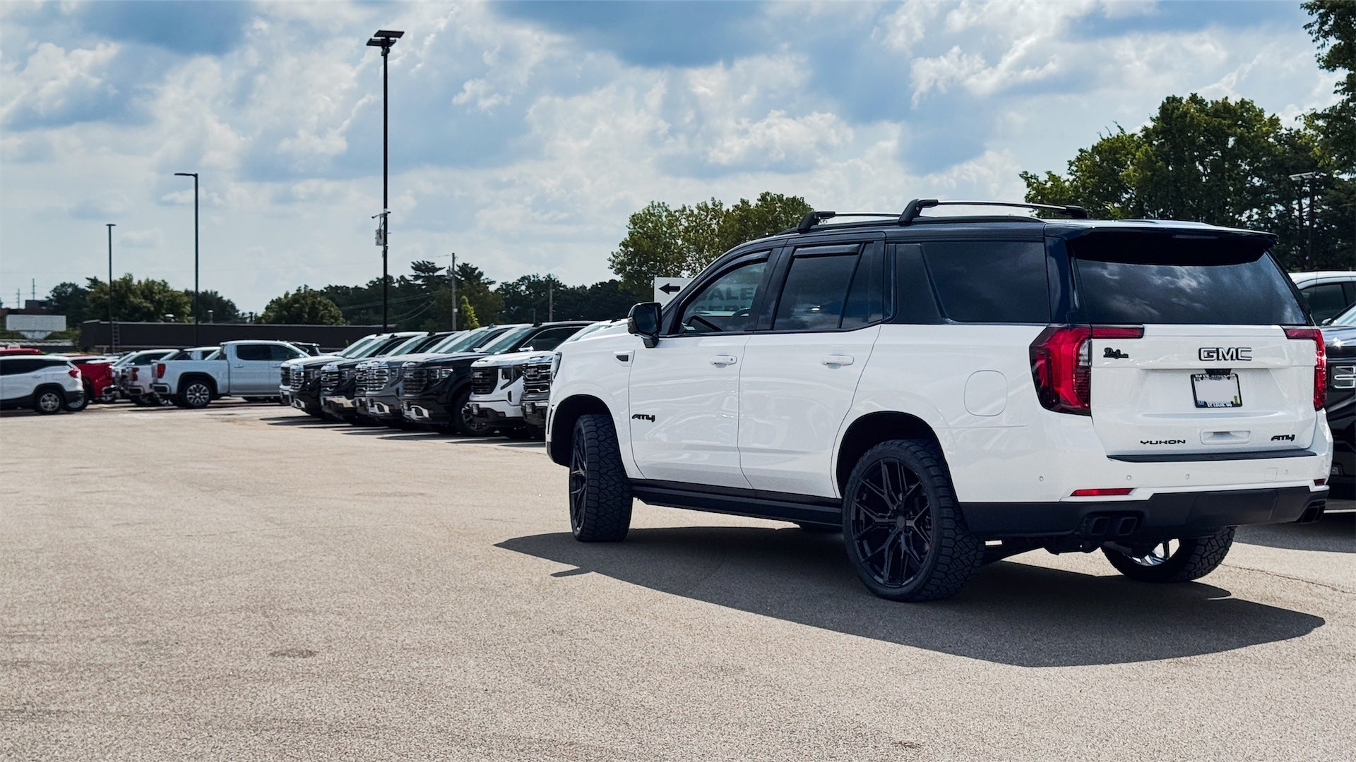 Side view of custom two-tone 2026 GMC Yukon AT4 Ultimate with roof cross rails