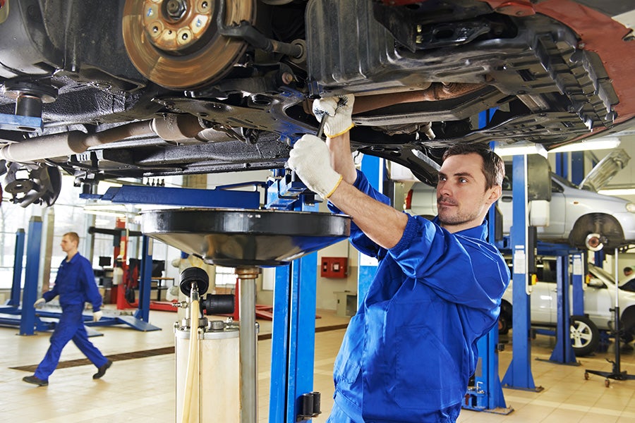 Mechanic working on car in shop